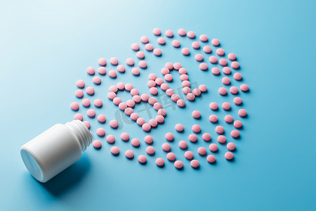 蓝色背景中心脏中 B12 形式的粉色药片，从白色罐头中溢出。