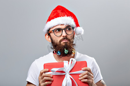 圣诞节、假期、理发店和风格概念 — 年轻英俊的留着胡子的圣诞老人男子，留着长胡子，有许多圣诞小玩意