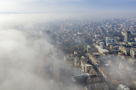 封面大气背景摄影照片_雾云从海上笼罩着城市，无人机拍摄的空中景观。