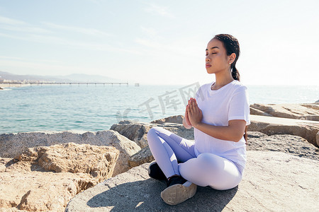 不平静的大海摄影照片_年轻女子在户外放松地冥想