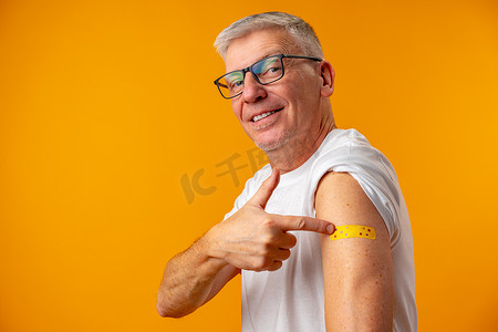 黄背景老人接受了冠状病毒疫苗接种