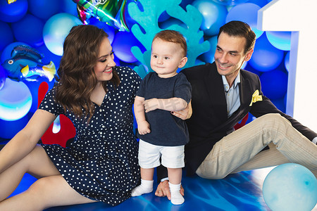 假期中，父亲、母亲和儿子以海洋风格的蓝色装饰为背景