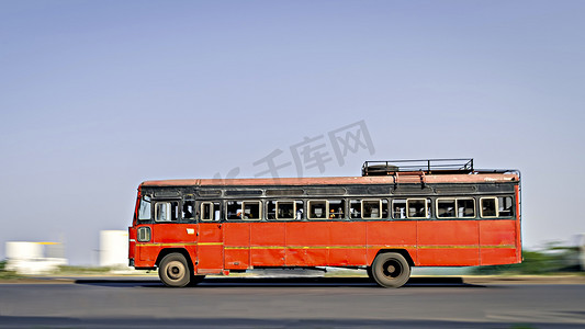 背景模糊，马哈拉施特拉邦非空调红色城际巴士在街上超速行驶的全景图像。