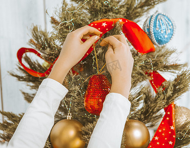 孩子们的手把装饰品挂在圣诞树上。