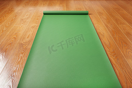 木地板上的绿色瑜伽垫展开。