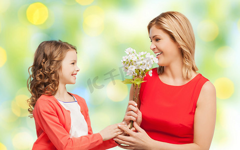 送母亲鲜花摄影照片_快乐的小女儿给妈妈送花