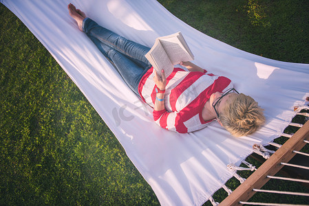 女人在吊床上放松地读书