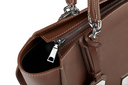 棕色皮革拉链手提包的特写，配有白色隔离的镀铬配件