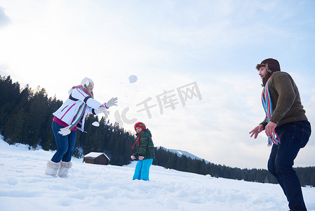 冬天幸福的一家人一起在雪地里玩耍