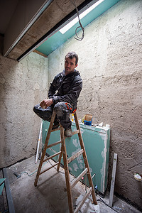 装备新升级摄影照片_建筑工人坐在梯子上的肖像