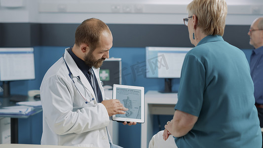 男医生在数字平板电脑上展示人体骨骼图