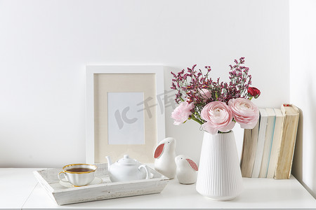 红色花卉摄影照片_白色桌子上的红色和粉色波斯毛茛花束。