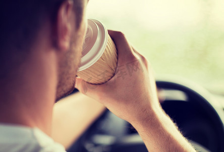 开车时喝咖啡的男人