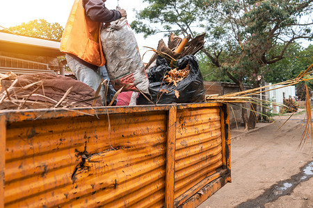 在尼加拉瓜马那瓜的一个贫困社区，一名市政工作人员在卡车顶上收集垃圾。