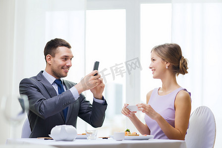 寿司图片摄影照片_微笑的夫妇拿着寿司和智能手机