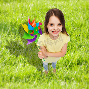 电人玩具摄影照片_带着彩色风车玩具微笑的孩子