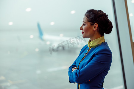 机场航站楼的女空姐望着窗外