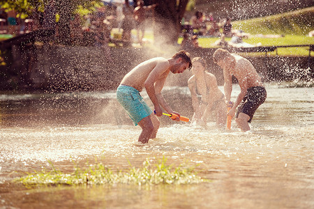 欢乐击球摄影照片_夏日欢乐朋友在河上玩耍