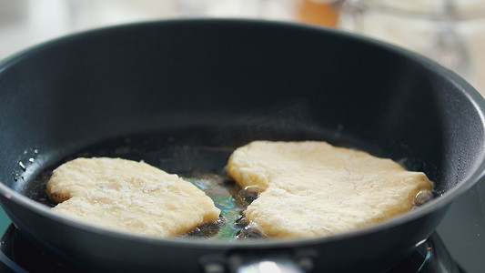 厨师心摄影照片_自制煎饼，形状像心形，在锅里炸薯条