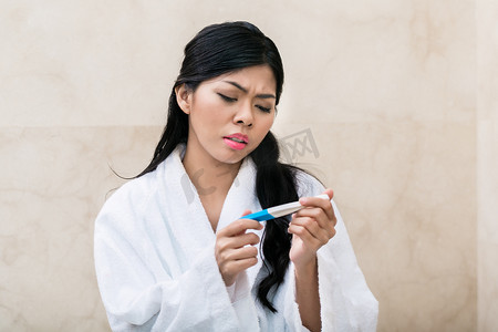 怀孕悲伤摄影照片_亚洲女性对妊娠测试感到悲伤