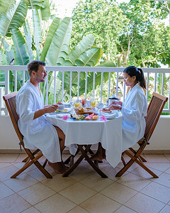 男女喝摄影照片_一对中年男女在毛里求斯豪华酒店公寓的阳台上吃早餐