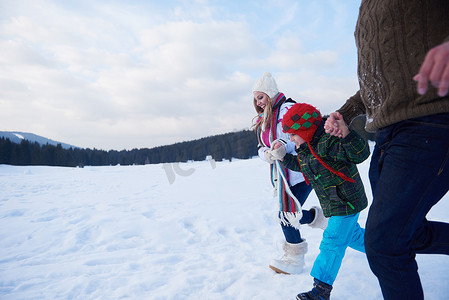 雪地里玩耍摄影照片_冬天幸福的一家人一起在雪地里玩耍