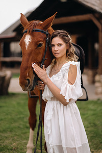 老牧场上一匹马旁边穿着白色太阳裙的漂亮女孩