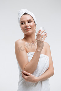 纯净水摄影照片_头上戴着白毛巾、喝着纯净水、看着别处的自信放松的女人
