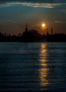 剪影景色摄影照片_日出时太阳下湄南河沿岸泰国寺庙剪影的美丽风景。