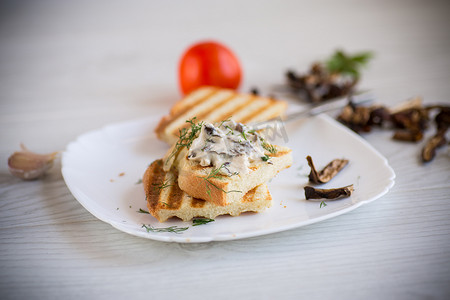 炸面包吐司配奶酪，在木桌上涂上煮熟的干蘑菇。