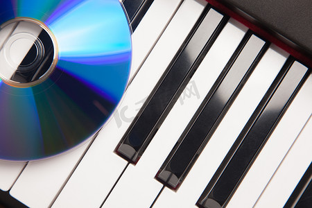 青花瓷光盘摄影照片_钢琴键盘上的 CD 抽象
