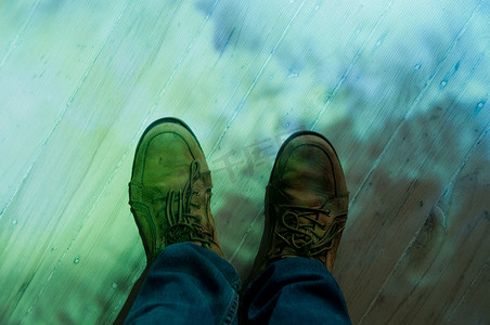 棕色皮鞋和蓝色牛仔裤站在彩色地板上