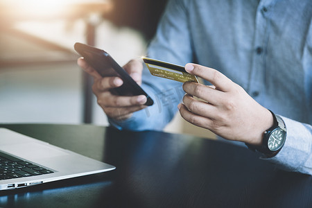网上购物和互联网支付，亚洲男性正在使用手机和信用卡在数字世界中网上购物或办事。