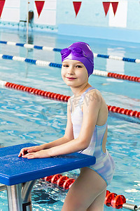 孩子游泳摄影照片_紫色橡胶帽子的女孩