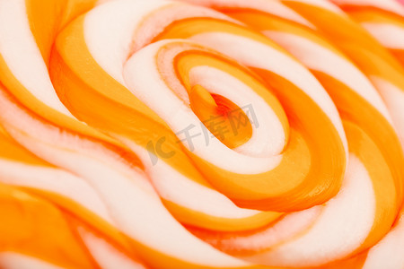 粉红色背景上的橙色圆形棒棒糖。