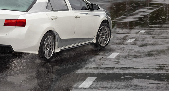 道路上的大雨和水坑导致汽车轮胎在潮湿的表面上打滑或滑动