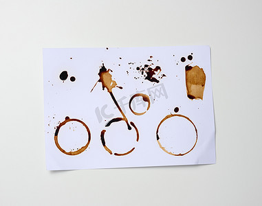 白纸，杯子底部有棕色印记，上面有咖啡、污迹和飞溅