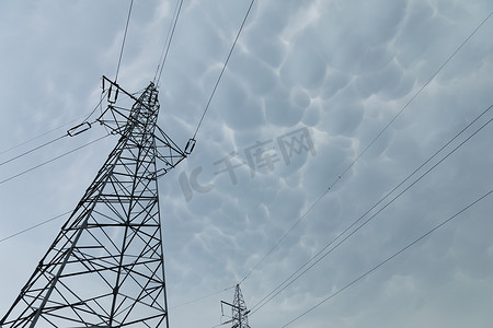 暴风漩涡摄影照片_在暴风云背景下用于架空传输折衷电力的杆。