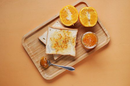 桌上的面包上铺着橙色水果