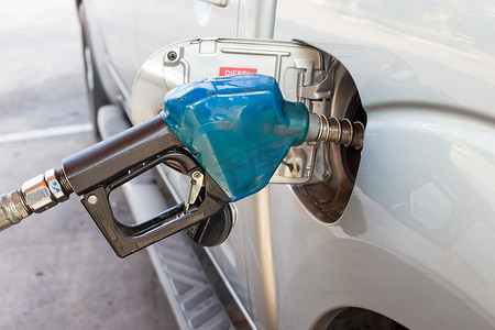 燃气泵摄影照片_青铜汽车油箱中的蓝色燃气泵喷嘴。