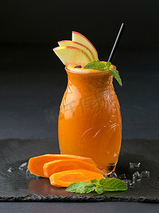 胡萝卜汁摄影照片_一罐苹果 — 胡萝卜汁和黑色背景中的配料