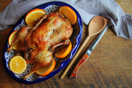 整只香脆金黄的烤鸭搭配新鲜橙片腌制，充满节日气氛。