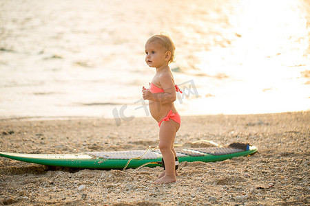 一个小女孩学习在海上冲浪。