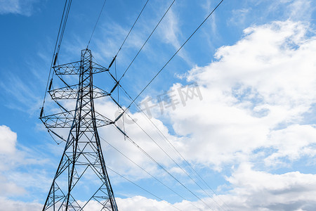 蓝色多云天空下英式电力塔和悬挂电缆的细节