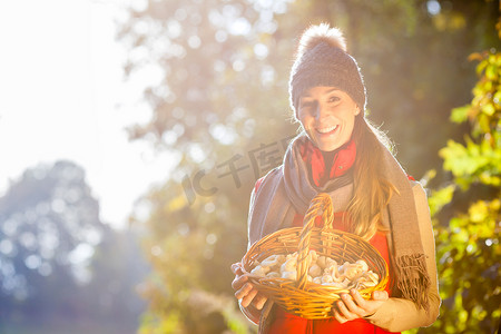 森林里提着装满蘑菇的篮子的女人