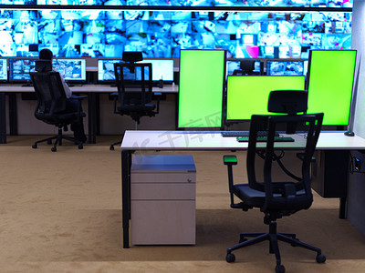 带空白绿色屏幕的大型现代安全系统控制室内部