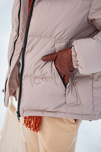 一个穿着冬季夹克的女孩，一只手放在卡姆兰