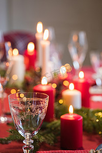 圣诞晚餐的餐桌、装饰着的节日氛围、燃烧的蜡烛和冷杉树枝
