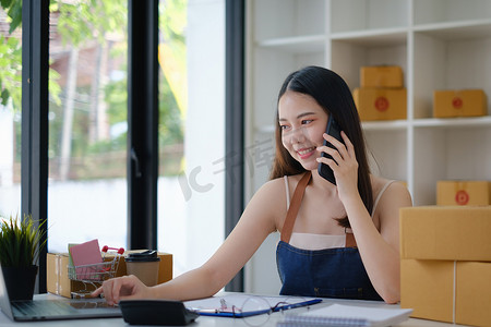 企业主在包装产品之前通过手机通话确认发送给客户订单的地址。