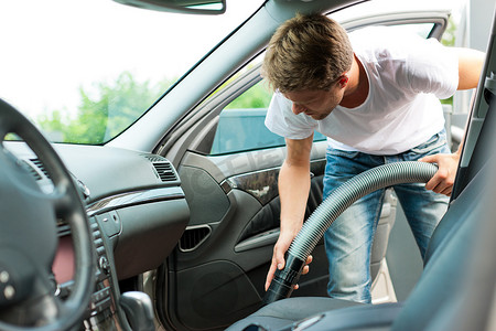 男人正在吸尘或清洁汽车